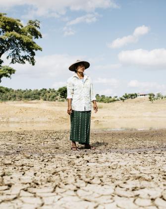 Ma Kyi Myint from Myanmar stands in her drought-afflicted field.